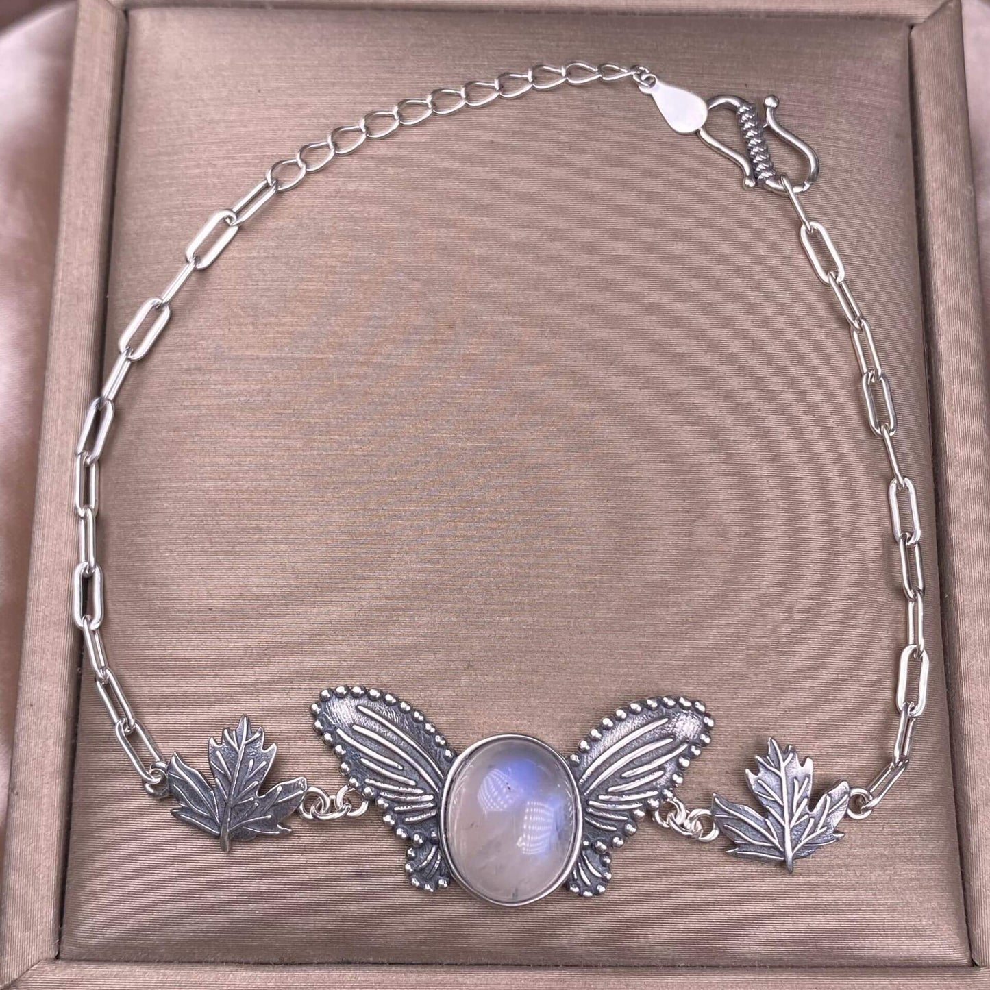 Silver necklace with butterfly and leaf design blue moonlight stone